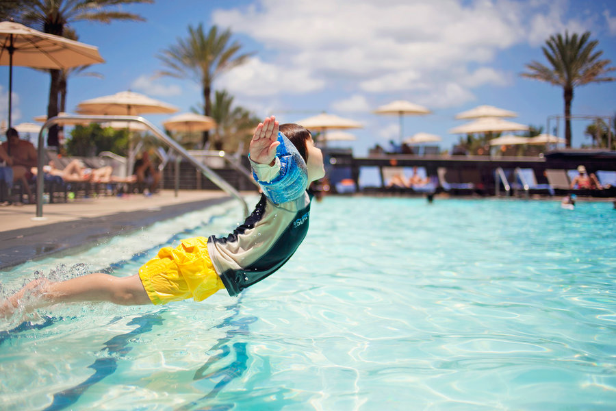 a boy jumps to the pool in Miami